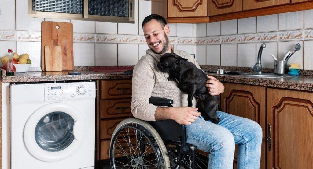 NDIS services Perth – man using a wheelchair with his dog at home, representing everyday disability support and daily living assistance.